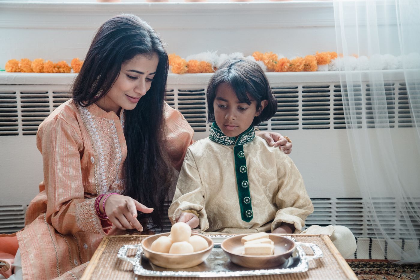 A mother and child preparing sweets together at home