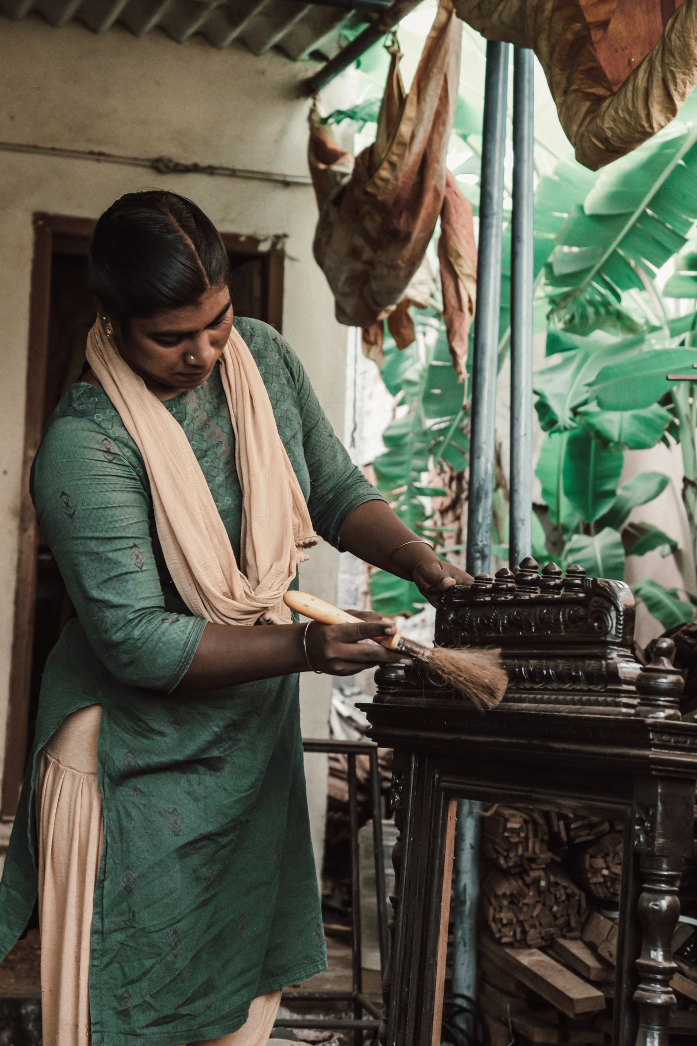 A woman tidying a carved wooden chair at home